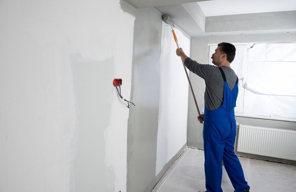painter applying paint to wall