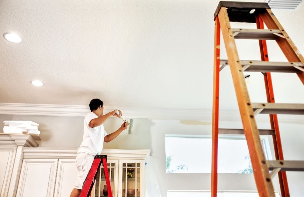 guy painting upper walls