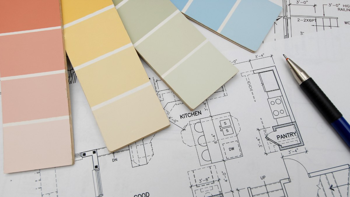 color paint swatches and a pen resting on an architectural blueprint