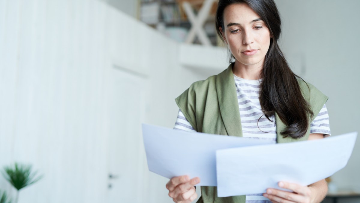 a woman reviewing papers held in her hands